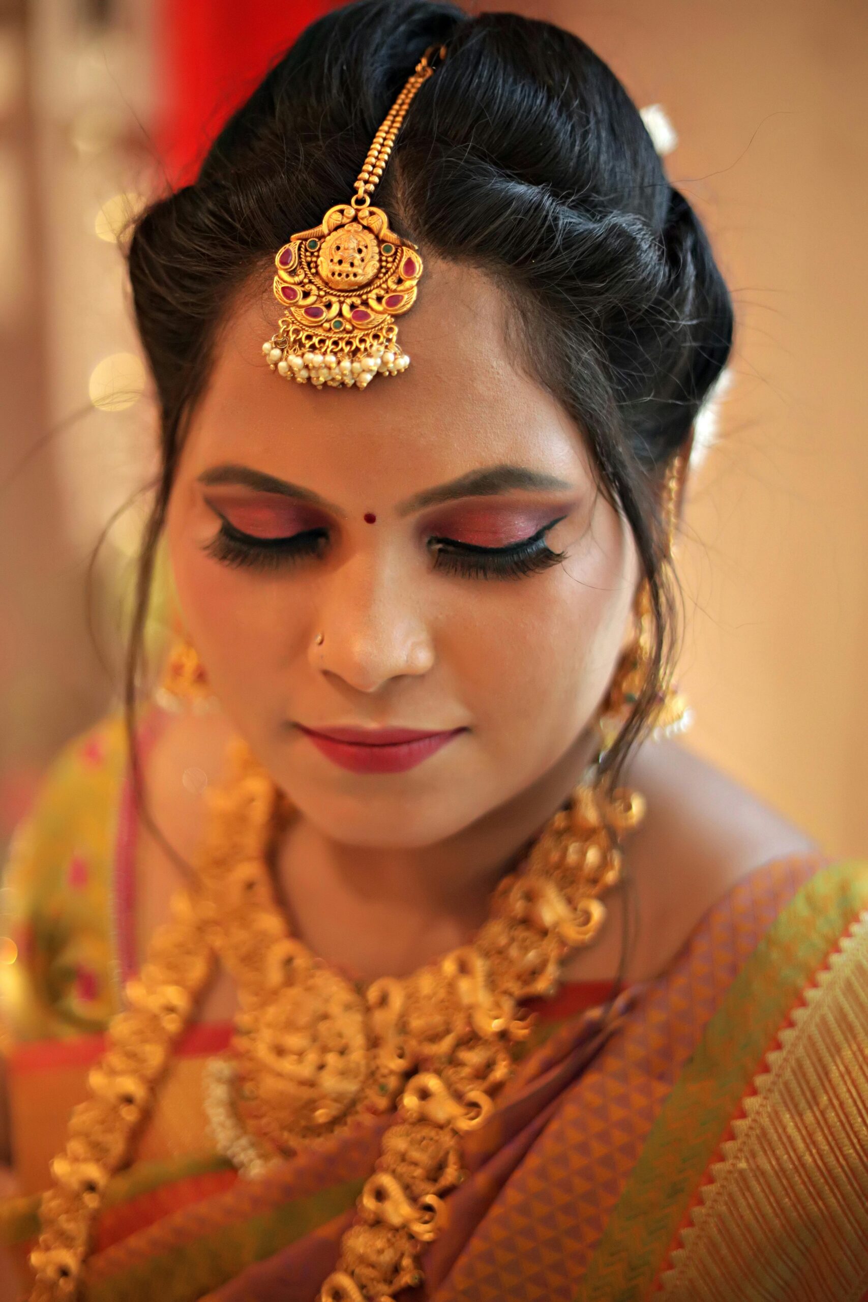 Young Indian woman in saree with traditional jewelry, eyes closed, exuding elegance.